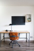 A workspace with a desk, a blackboard, a leather chair, and a glass vase on the wall.