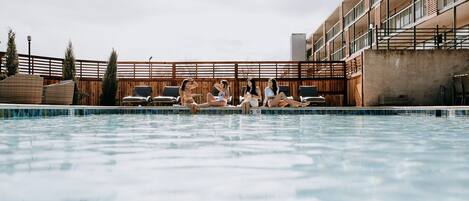 En säsongsöppen utomhuspool och solstolar