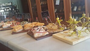 A variety of appetizers on wooden boards, each labeled with a name in a foreign language. - Hotel Rural La Puerta de la Ribera (Sardon de Duero)