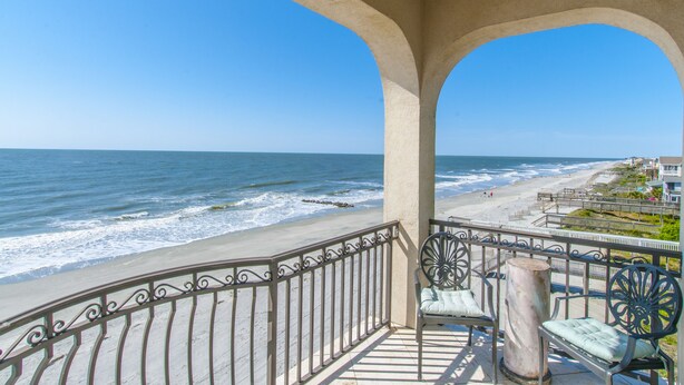 Un balcon avec vue sur la plage et l’océan.