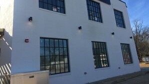 A white building with multiple windows and a sign that reads "INTERSECT THREE CULTURE". - The Hotel at Huntington Square (Jonesboro)
