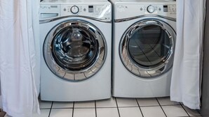 Two front-loading washing machines in a laundry room with tiled flooring. - Spacious, budget friendly 3 BR House! (Gulf Shores)