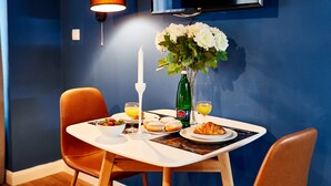 Une table à manger avec des aliments pour le petit-déjeuner, une bougie et un vase de fleurs.