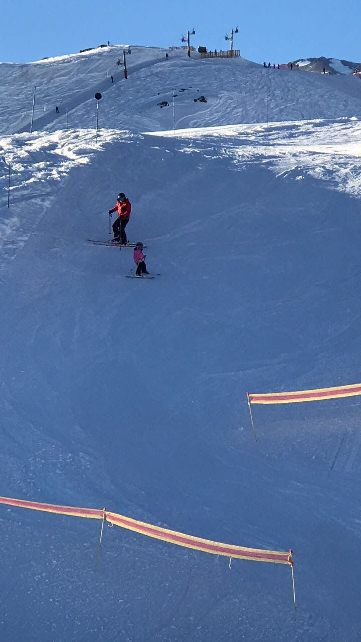 A ski slope with skiers descending.