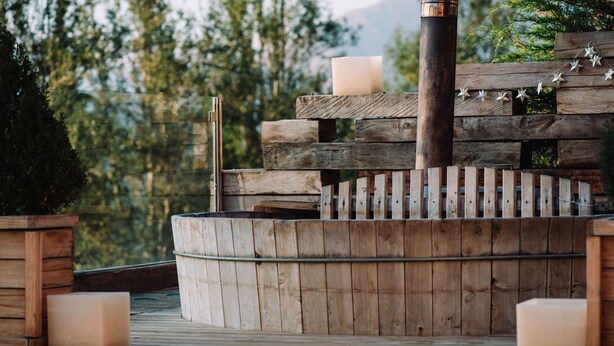 Une terrasse en bois agrémentée d’un foyer rustique, entourée de rampes en bois et de décorations en forme d’étoiles.