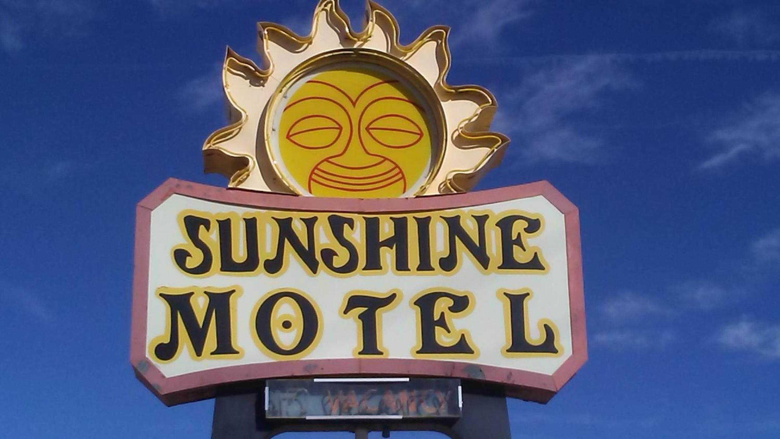 A motel sign with a sun emblem and the name 'Sunshine Motel'.