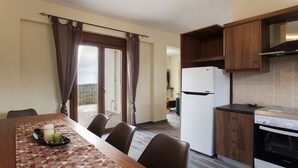 A kitchen with a white LG refrigerator, wooden cabinets, and a built-in oven. - Foivos and Athina Villas (Archanes-Asterousia)