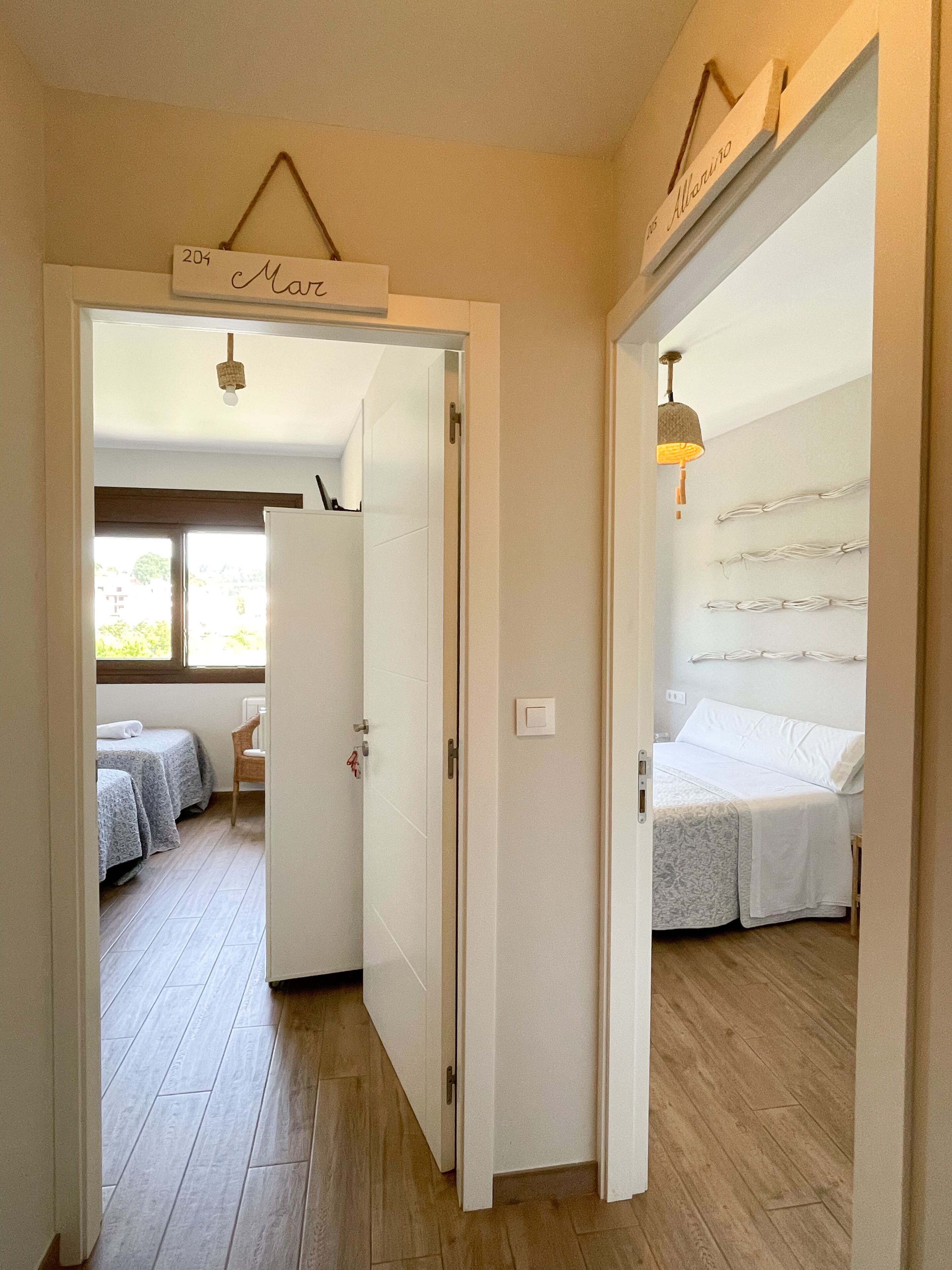Habitación de hotel con cama, una silla y una mesita. Hay una ventana con vistas al exterior.
