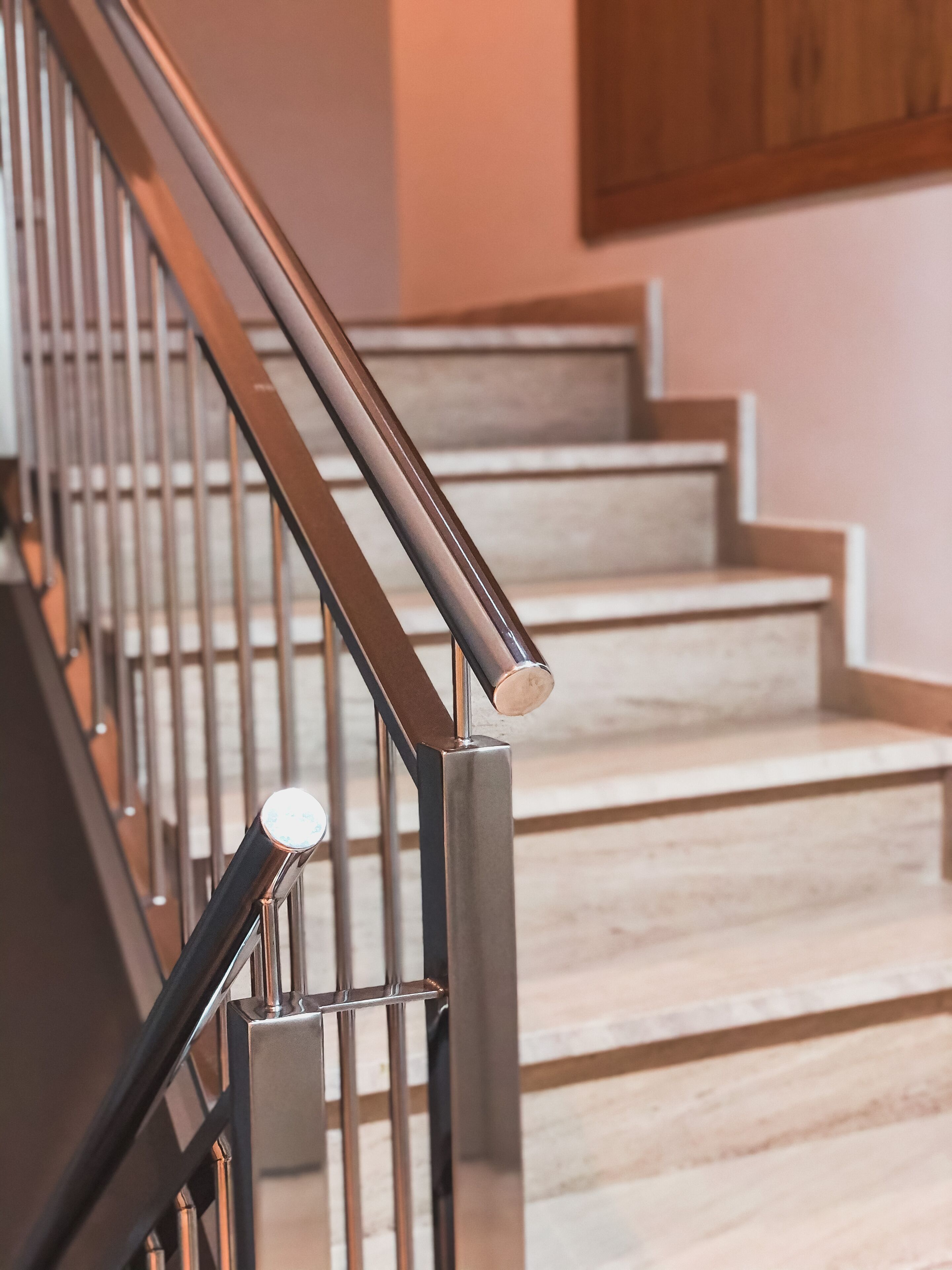 Una escalera con barandilla de metal y pared de madera.