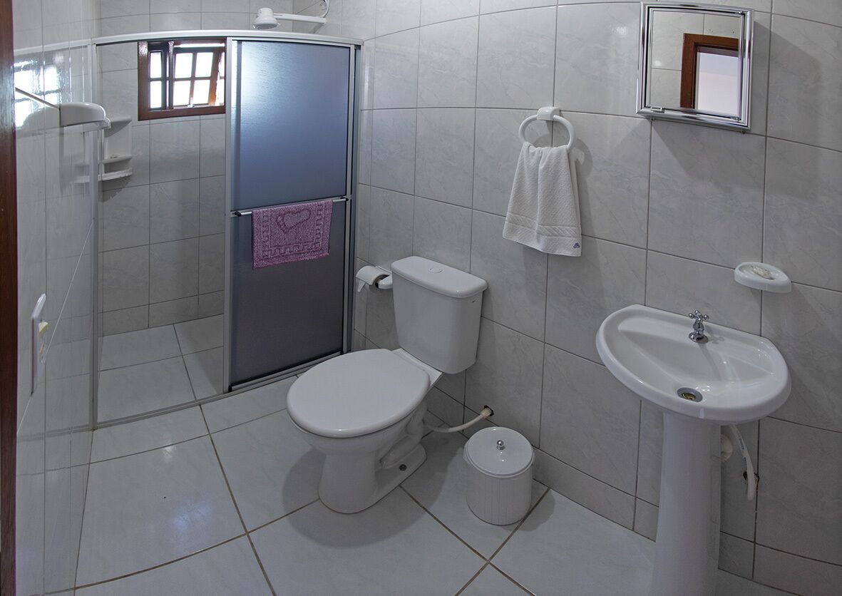 Un baño con inodoro, lavamanos y ducha.