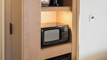 A compact kitchenette with a microwave, a coffee maker, and a dishwasher.