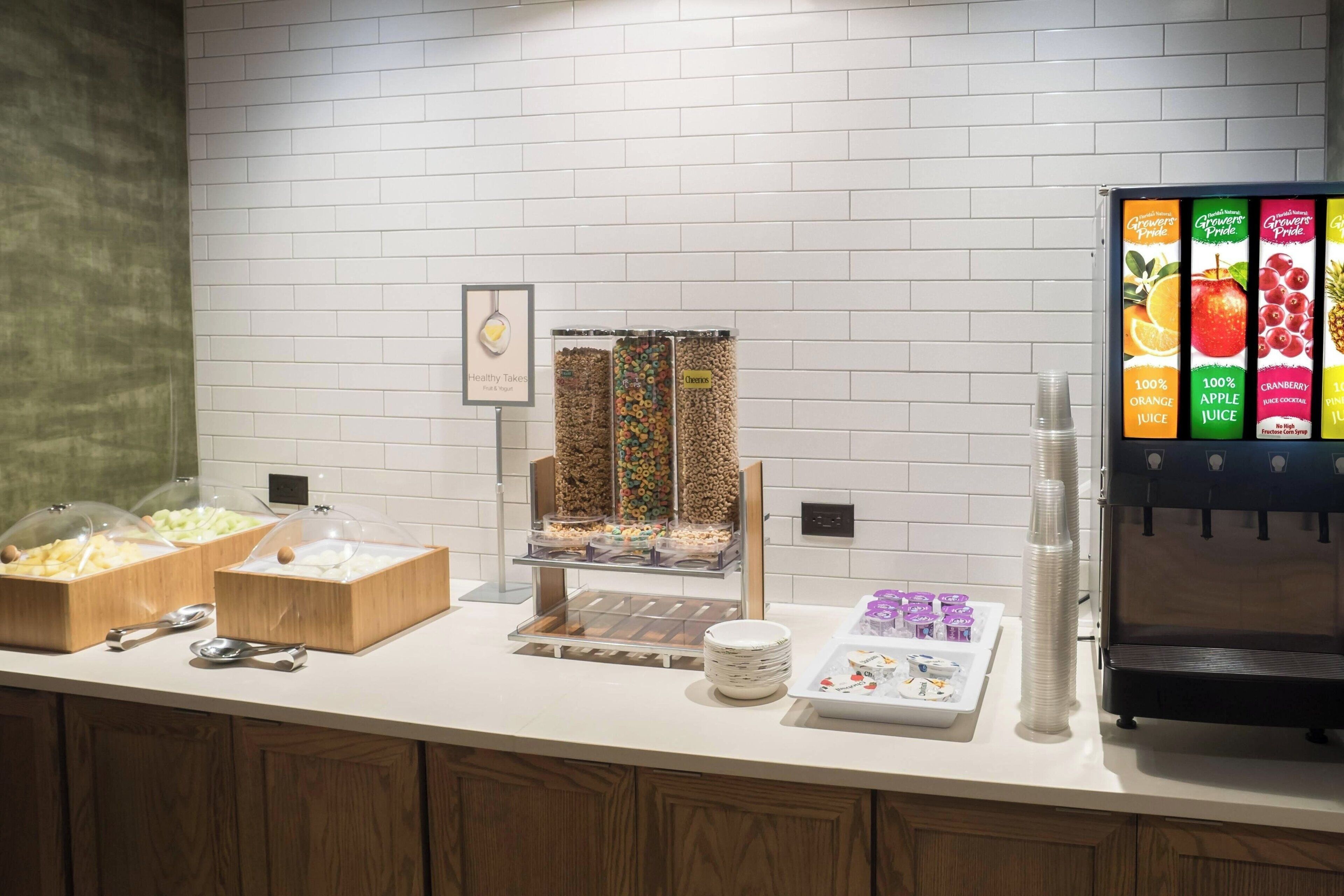 A buffet setup with various food items and a beverage dispenser.