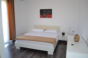 Ein modernes Schlafzimmer mit Bett, Nachttisch und einem an der Wand hängenden Kunstwerk.