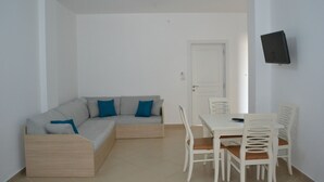 A modern living room with a sofa, dining table, and chairs.