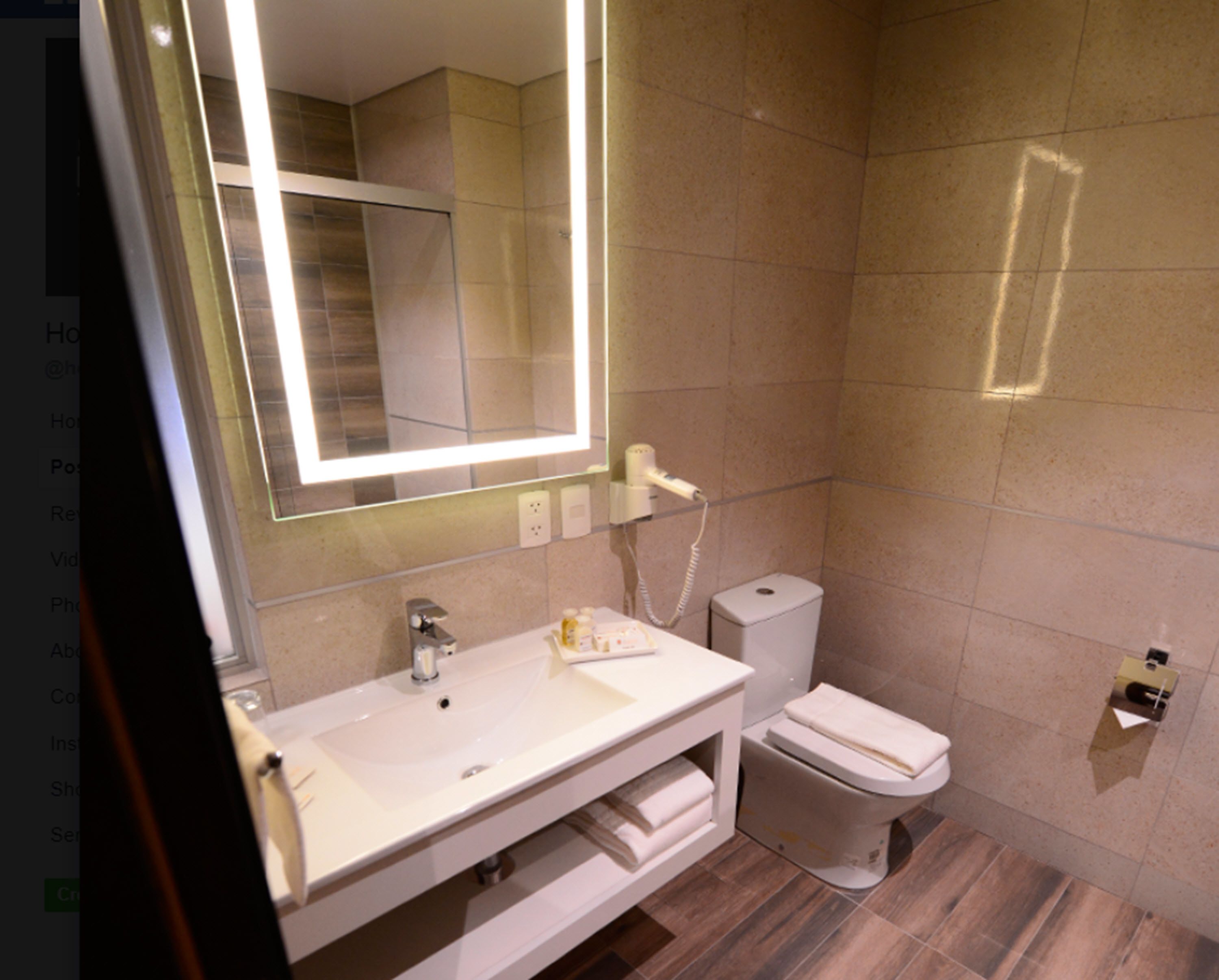 Un baño moderno con tocador blanco, un espejo grande, un inodoro y una zona de ducha.