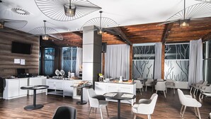 A modern hotel lobby with a central bar area, seating arrangements, and a wooden ceiling. - Hotel Rennova (La Paz)