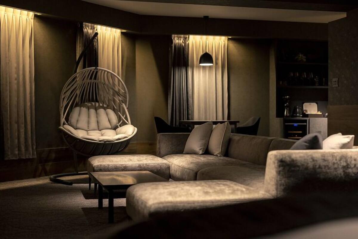 Een moderne woonkamer met een hoekbank, een hangstoel en een salontafel.