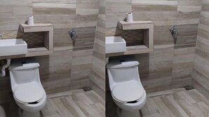 A bathroom with two toilets, a sink, and a mirror.