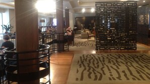 A modern interior with a central seating area, a patterned rug, and a decorative wall panel. - Heritage Apartment (Auckland)
