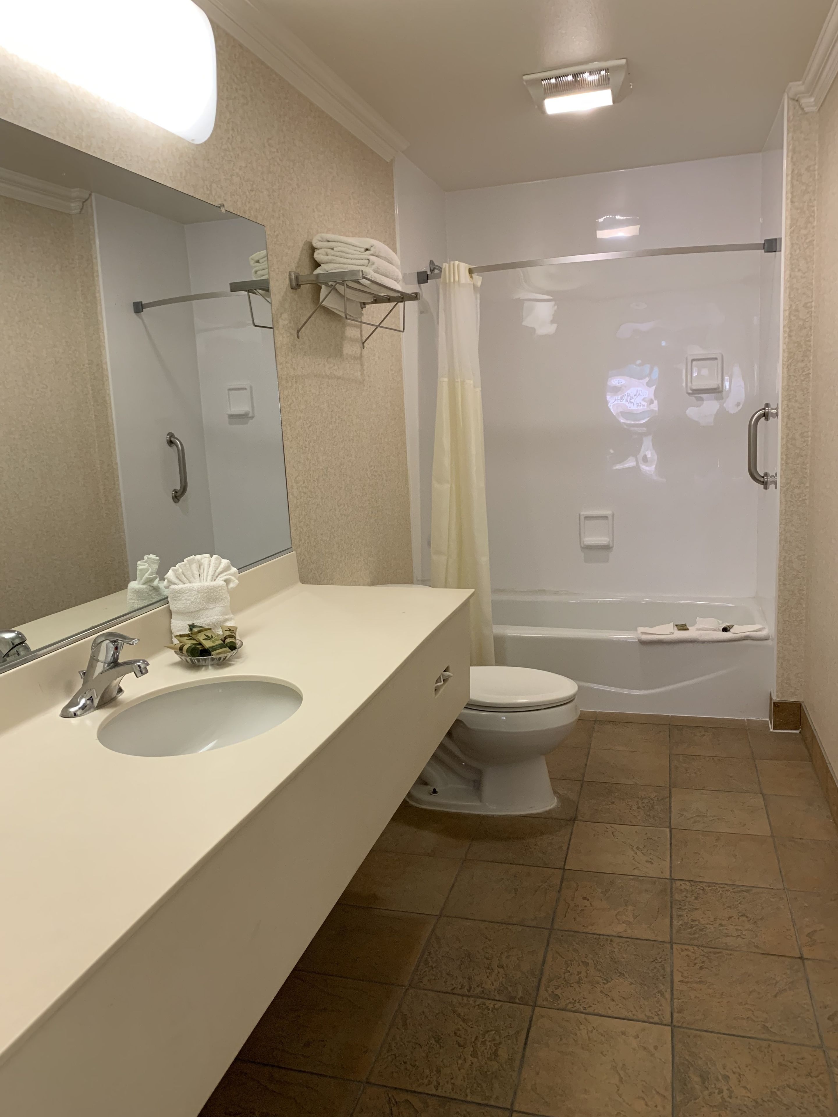 A bathroom with a sink, toilet, and shower.