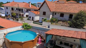 A residential area with a swimming pool, a covered patio, and a view of neighboring houses. - Casa Praia da Nazare (Nazaré)