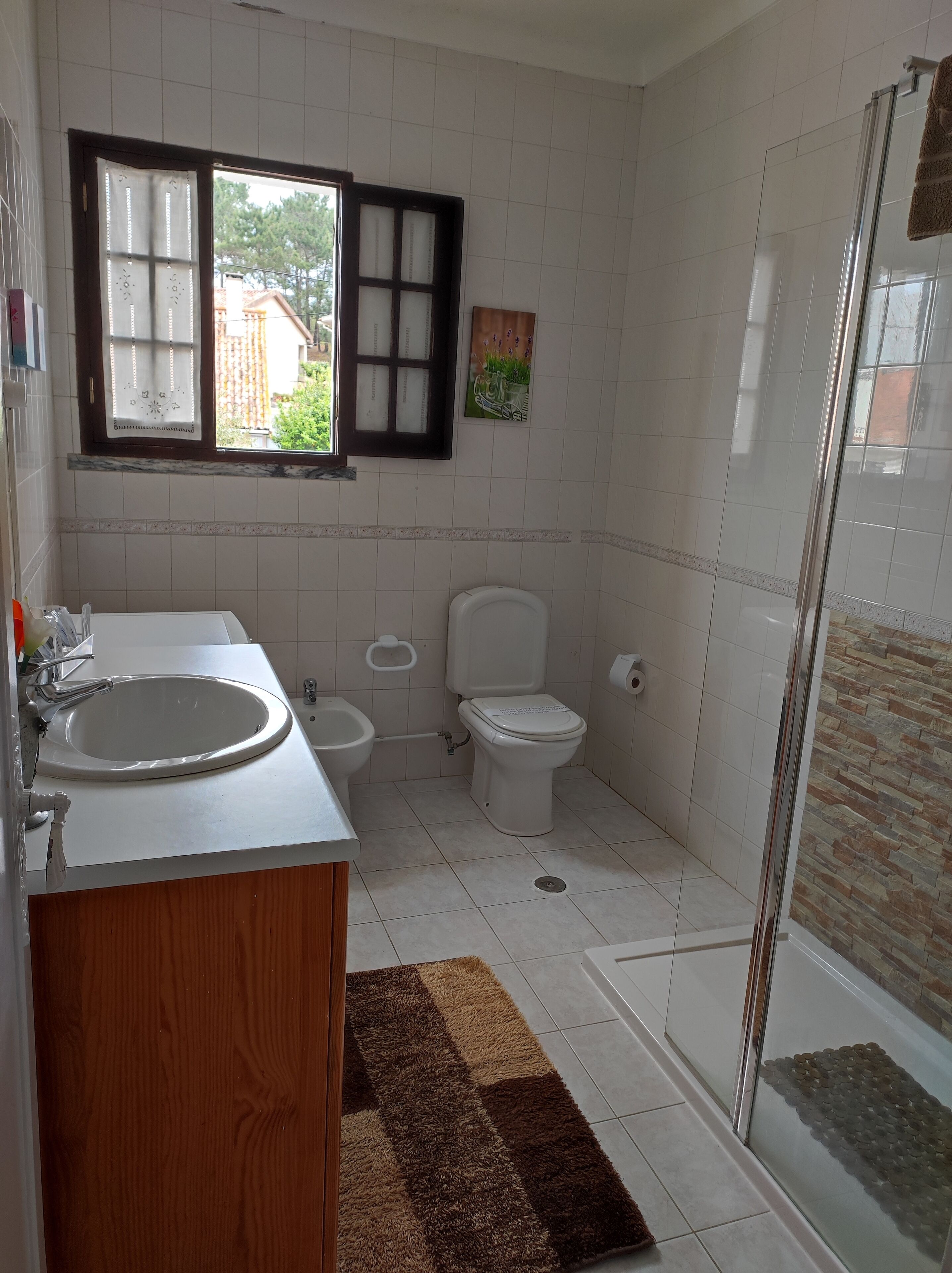 A bathroom with a sink, toilet, and shower.