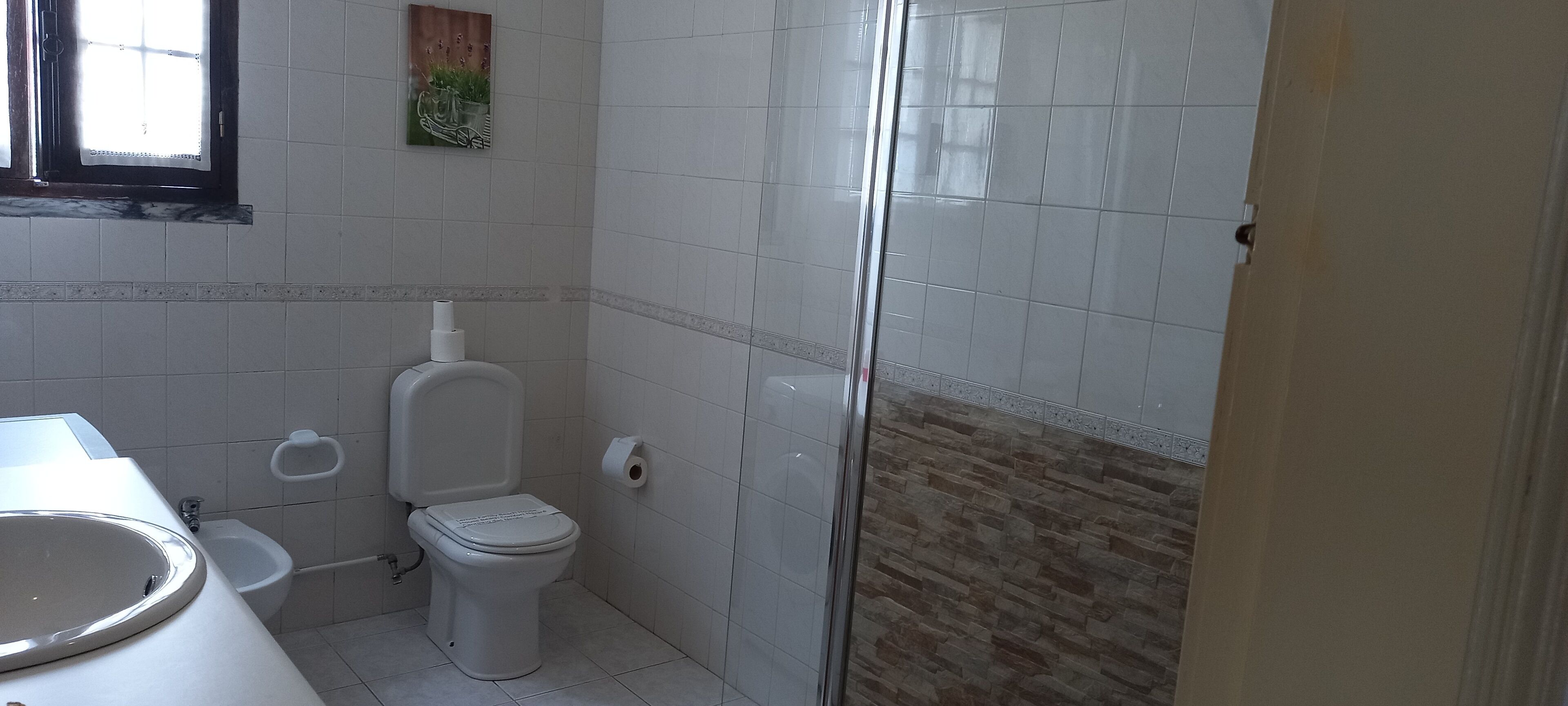 A bathroom with a toilet, bidet, and sink.