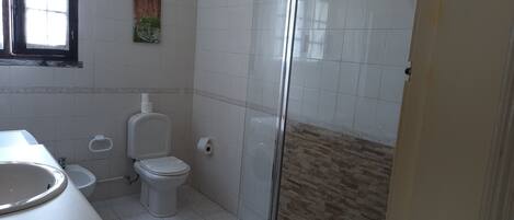 A bathroom with a toilet, bidet, and sink.