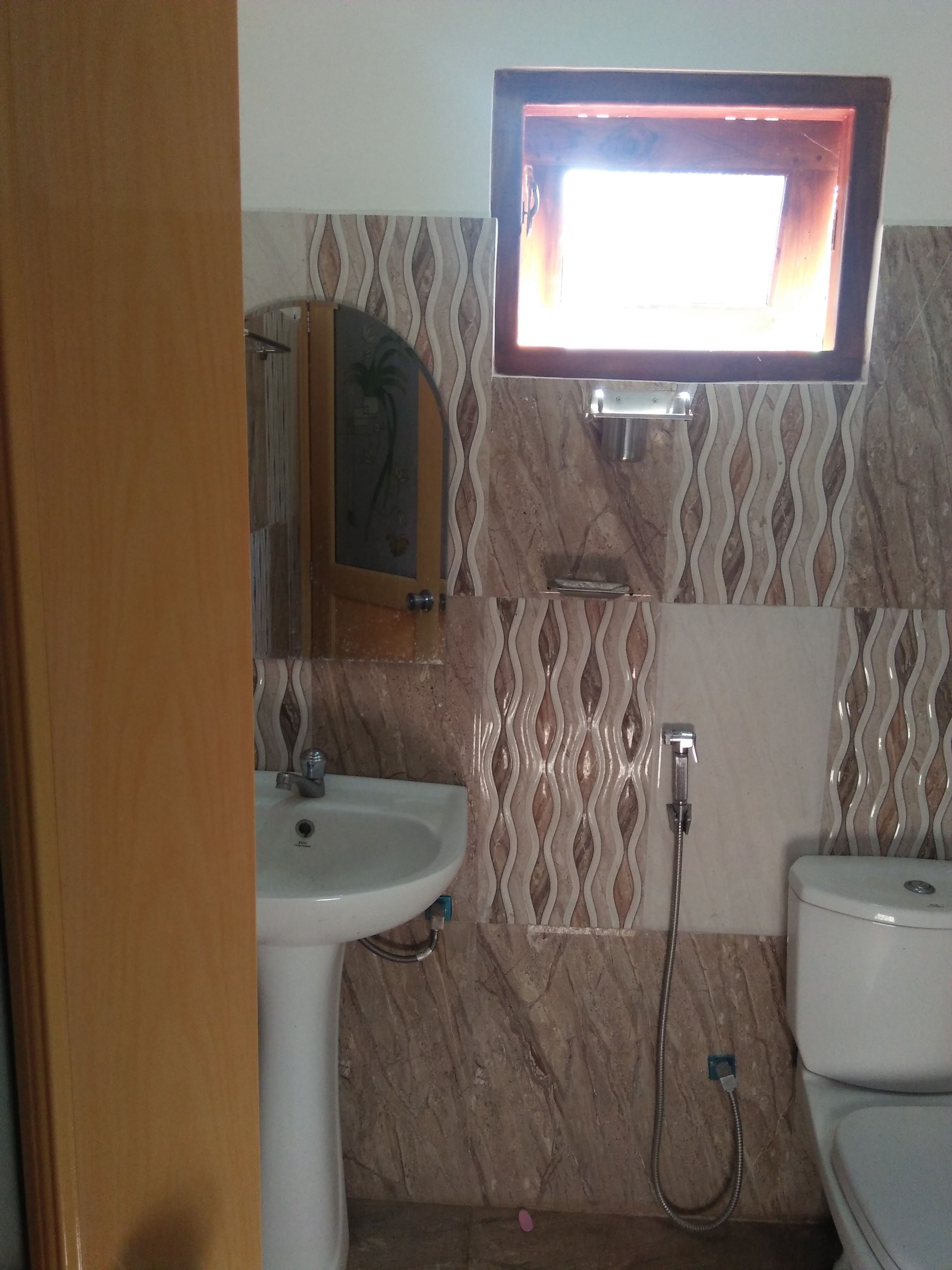A bathroom with a sink, toilet, and a mirror above the sink.
