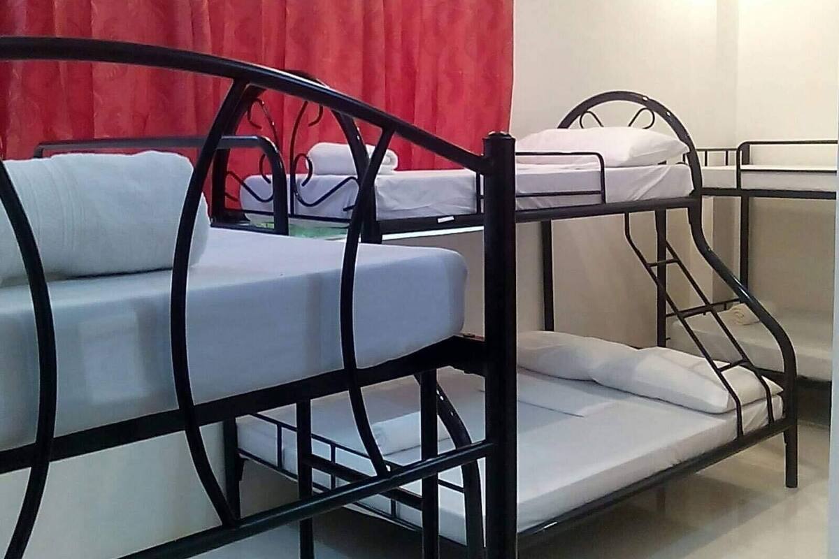 A bunk bed room with a red curtain in the background.
