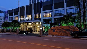 Un hotel moderno con una entrada destacada y un letrero grande.