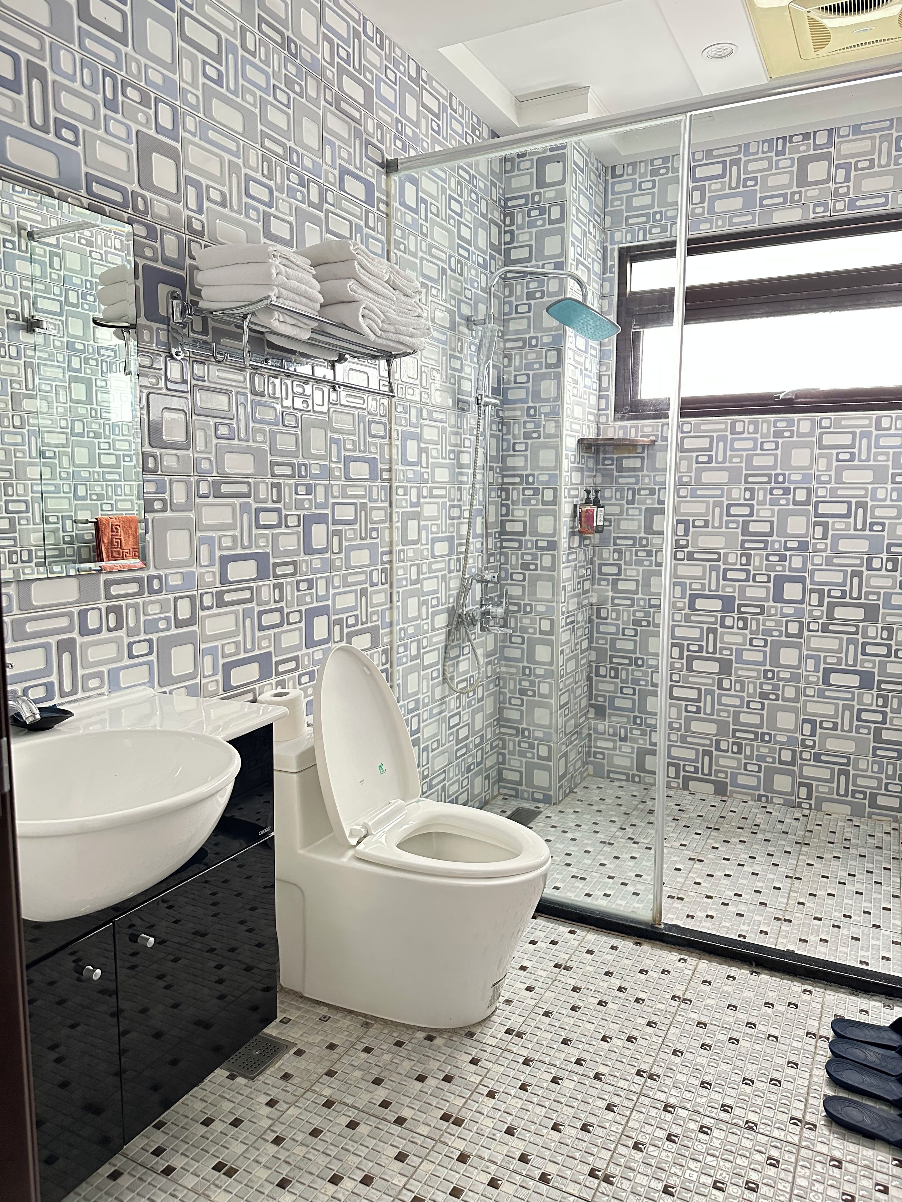 A bathroom with a white sink, a toilet, and a shower area.
