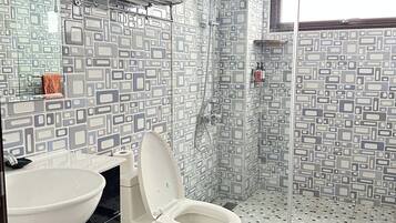 A bathroom with a white sink, a toilet, and a shower area.