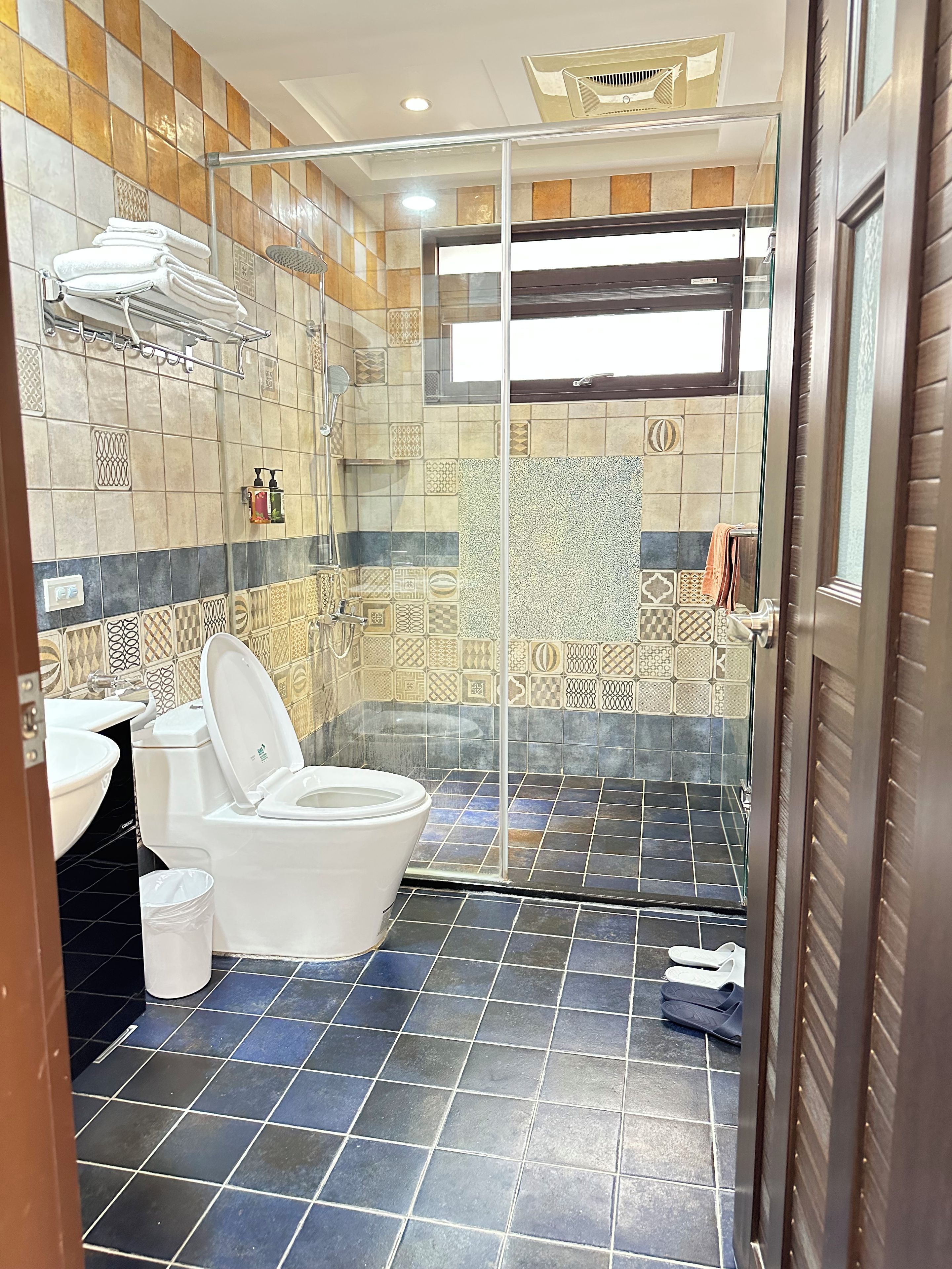 A bathroom with a shower, toilet, and sink.