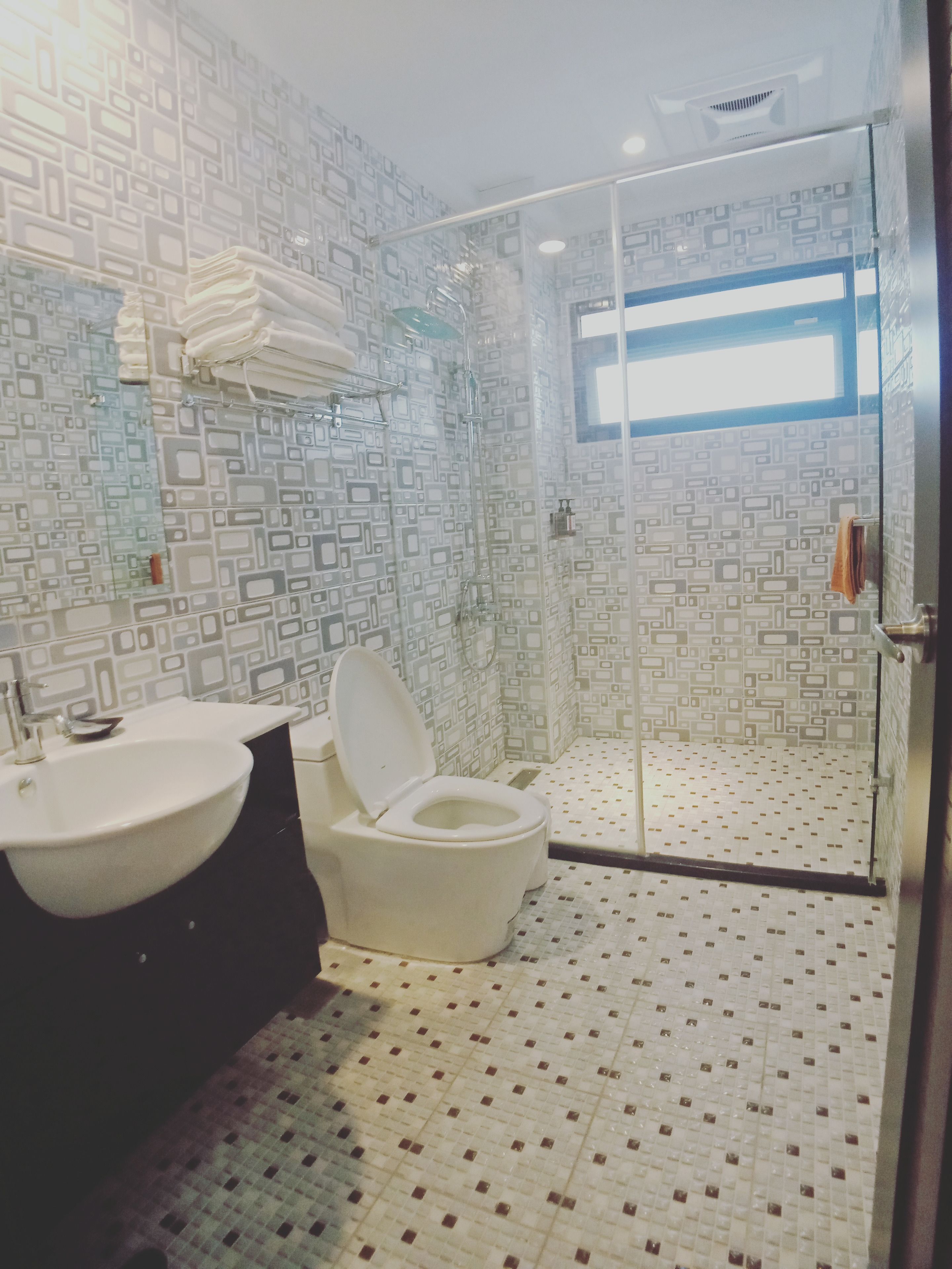 Casa de banho com design moderno, incluindo sanita, lavatório e zona de duche.