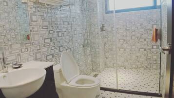 Casa de banho com design moderno, incluindo sanita, lavatório e zona de duche.