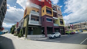 Un edificio de varios pisos con la parte superior roja, el centro amarillo y la base verde.