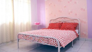 A bedroom with a bed, a small bedside table, and a wall with floral wallpaper. - Manis-Manis Pink Lady Cottage (Malacca City)