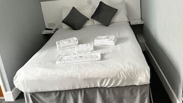 Escritorio, tabla de planchar con plancha y ropa de cama