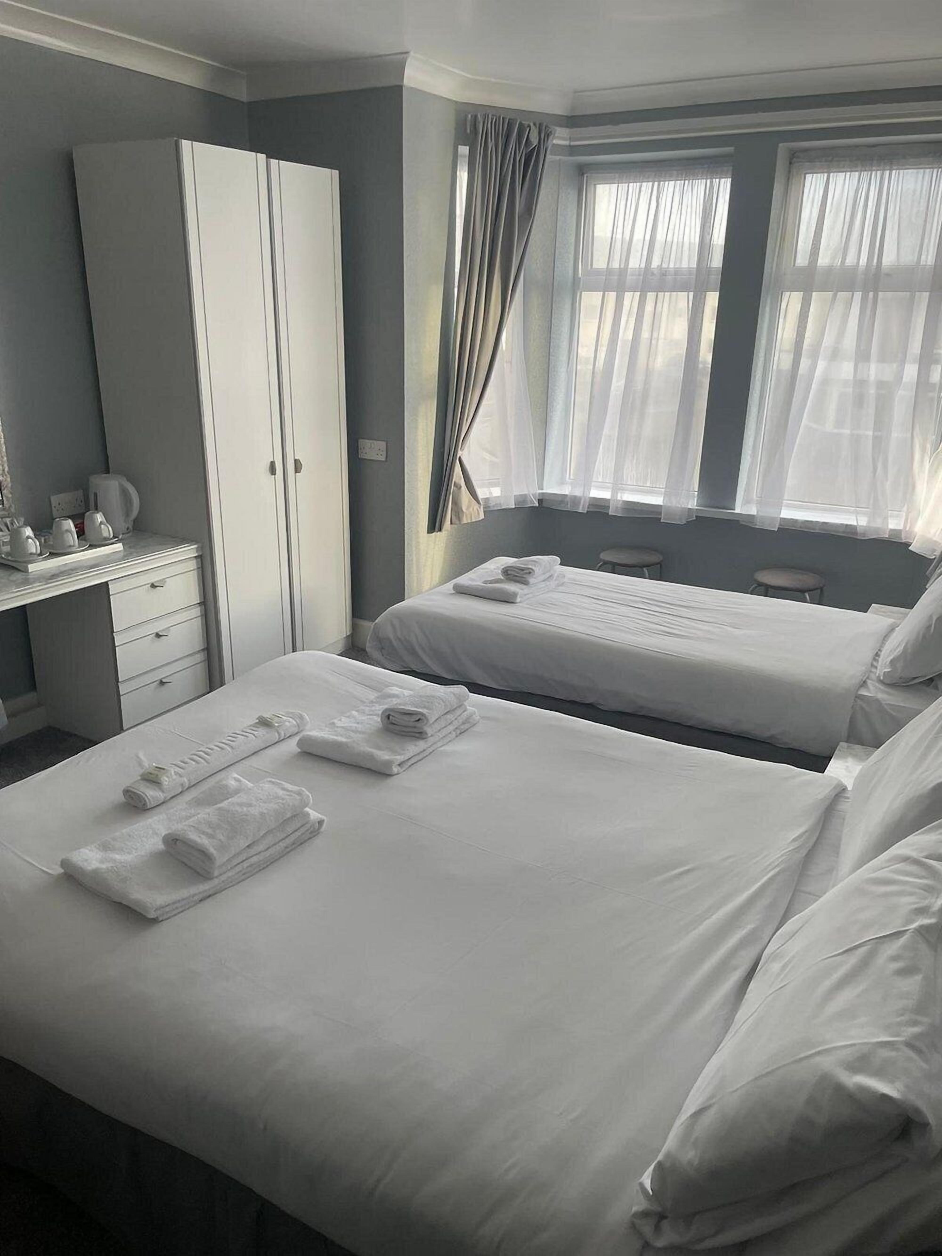 Familiekamer | Een bureau, een strijkplank/strijkijzer, beddengoed