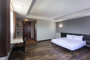 A modern hotel room with a bed, a desk, and a chair. - Iron Resort&Hotel (Phitsanulok)