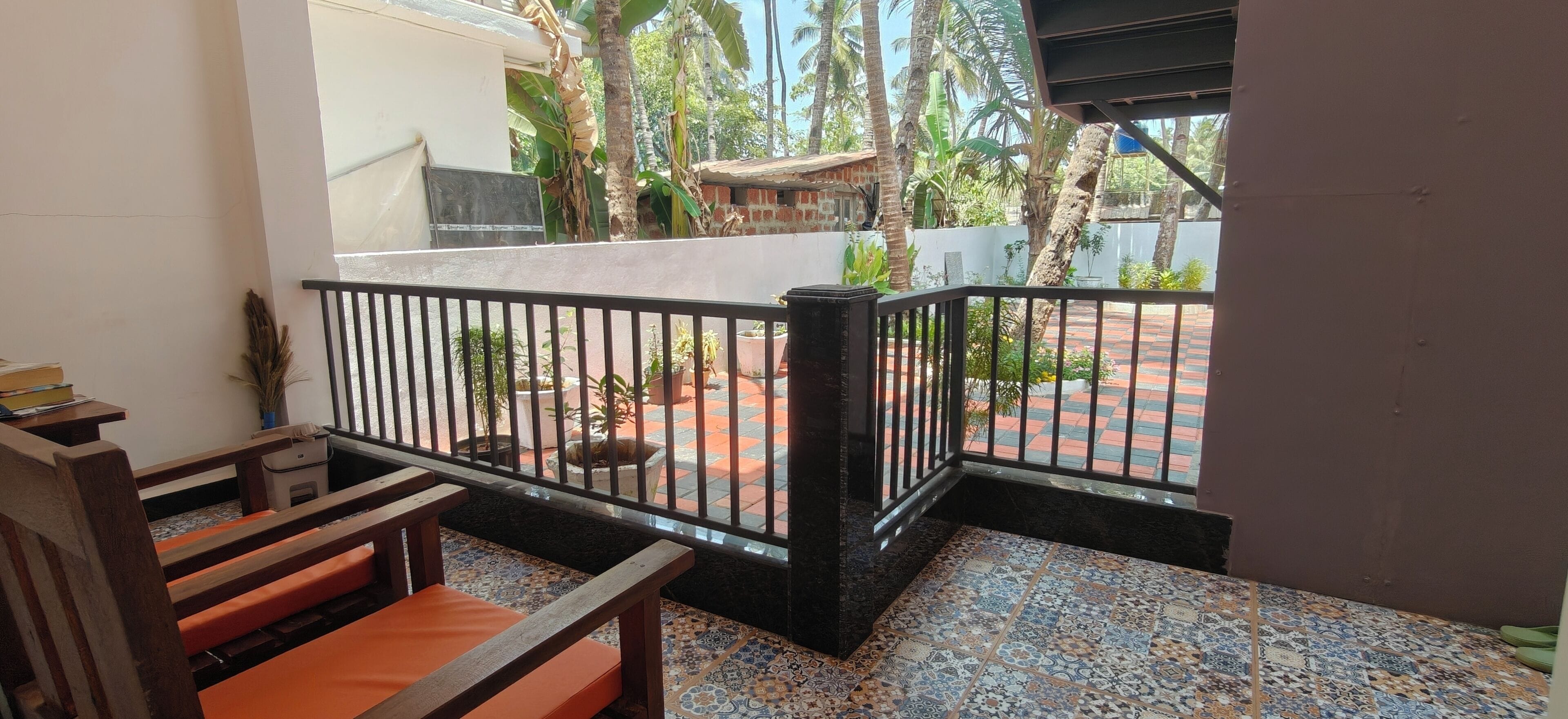 A balcony with a tiled floor, a wooden bench, and a railing.