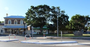 A building with a clock, a sign for 'Burra Visitor Centre', and a 'Terry White Chemist'. - Royal Exchange Hotel (Burra)