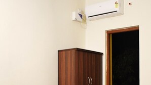 A bedroom with a bed, a wardrobe, a ceiling fan, and an air conditioning unit. - La Vega Resort (Morjim)
