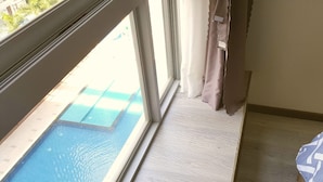Ein Zimmer mit Blick auf einen Außenpool durch ein Fenster.