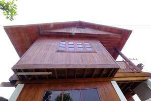 Un edificio de madera de varios niveles, con techo inclinado y una ventana central.