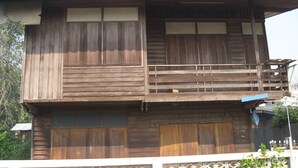 Una casa de madera de dos pisos con un balcón en el nivel superior.