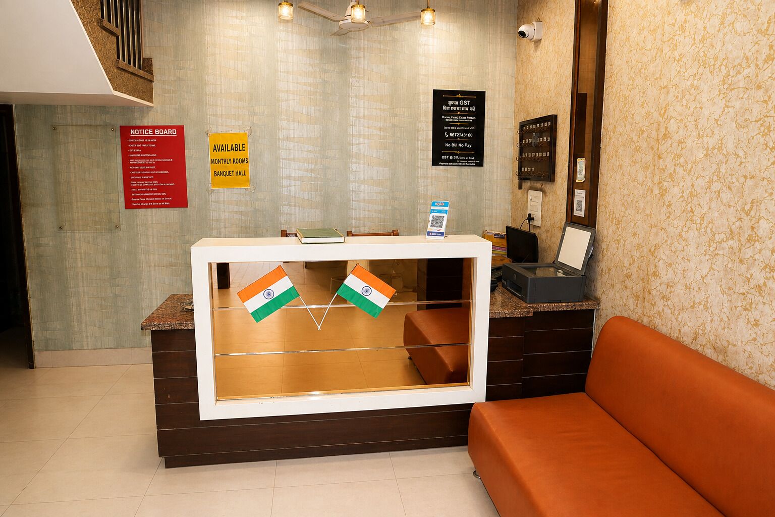 A reception desk with two flags, a notice board, and a QR code.