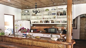 Une cuisine dotée d’un comptoir en bois, de divers appareils électroménagers et d’étagères remplies d’ustensiles de cuisine.