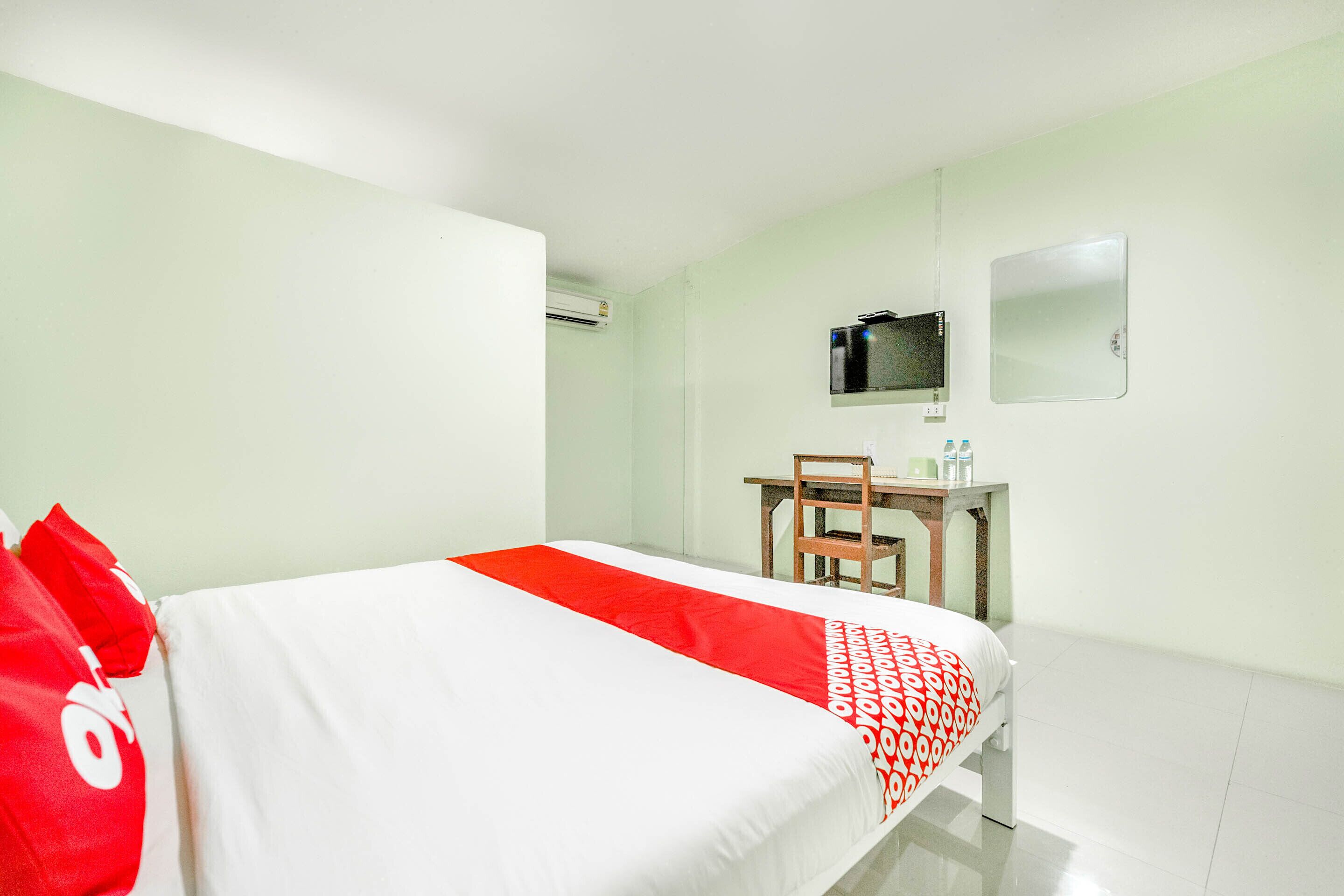 Una habitación de hotel con una cama, un escritorio y una silla.